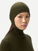 Person wearing an olive green knit beanie and turtleneck against a light gray background #color_olive-green