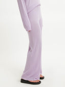 A person wearing purple silk cashmere wide-leg pants with a mid-rise waist and elasticated hems. #color_orchid-bloom