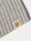 Gray knit beanie with a brand tag on a white background #color_light-gray