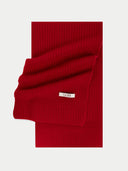 Red knitted blanket with a visible brand label on a light gray background #color_warm-red