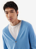 Man wearing a light blue cardigan over a white shirt on a white background. #color_lichen-blue