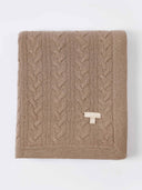 Brown cable knit blanket with a logo on a white background. #color_taupe