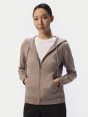 Model wearing the taupe cashmere zip hoodie open over a white tee, hands in the smiley pockets, front view
