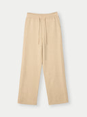 A pair of beige wide-leg sweatpants with an elastic waistband and matching drawstring, shown flat against a light gray background.