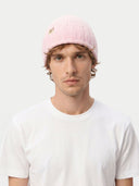 Man wearing a pink beanie with a logo on a white background. #color_pink #ai-image