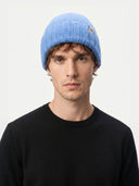 Man wearing a blue knit beanie against a white background. #color_blue #ai-image