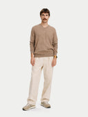 Man wearing a brown sweater and beige pants on a white background. #color_taupe #ai-image