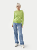 Person wearing a green jumper and blue jeans on a white background #color_white