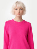 Person wearing a bright pink sweater on a white background. #color_magenta-pink #ai-image