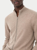 Beige zip-up jumper worn by a person on a light grey background #color_taupe