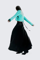 Model in turquoise ribbed cropped cashmere jumper and long black skirt, back view, cyber monday cashmere sale
