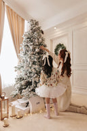 GOBI Cashmere 2023 review scene: woman and child in cream knitwear decorating a snowy Christmas tree beside GOBI gift boxes