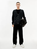 Man wearing a black cardigan, black shirt, black pants, and white shoes on a white background. #color_charcoal