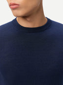 Navy blue sweater worn by a person on a light gray background. #color_dark-indigo