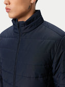 Navy blue puffer jacket worn by a person on a white background