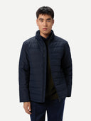 Man wearing a navy puffer jacket on a white background