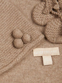Close-up of a beige knitted fabric with tassels and a Gobi Organic label.  | GOBI UK #color_taupe