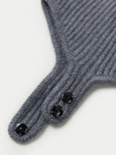 Gray knitted glove with black buttons on a light gray background