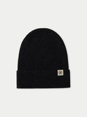 Black beanie with a logo tag on a light gray background