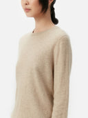 Beige sweater worn by a person on a white background. #color_soft-beige