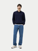 Man wearing a navy sweater and blue jeans on a white background. #color_navy #ai-image