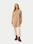 Woman wearing a beige sweater and white pants on a white background. #color_beige #ai-image