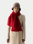 Person wearing a red scarf, beige coat, and brown hat on a white background #color_taupe