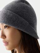 Person wearing a gray knit beanie against a neutral background