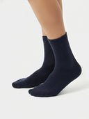 Navy blue socks worn by a person on a white background