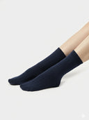 Navy blue socks worn by a person on a light gray background