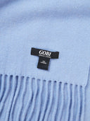 Close-up of a light blue scarf with a Gobi label. #color_deep-slate