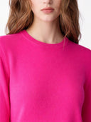 Close-up of a person wearing a bright pink jumper on a white background #color_white