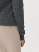 Gray sweater worn by a person on a plain background. #color_dark-gray
