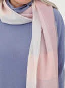 Person wearing a light pink and purple scarf with a blurred background