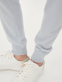 Light gray sweatpants worn with white sneakers on a light background. #color_ice-blue