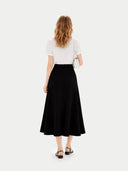 back view of a woman wearing a white top and black skirt on a white background. #color_black #ai-image