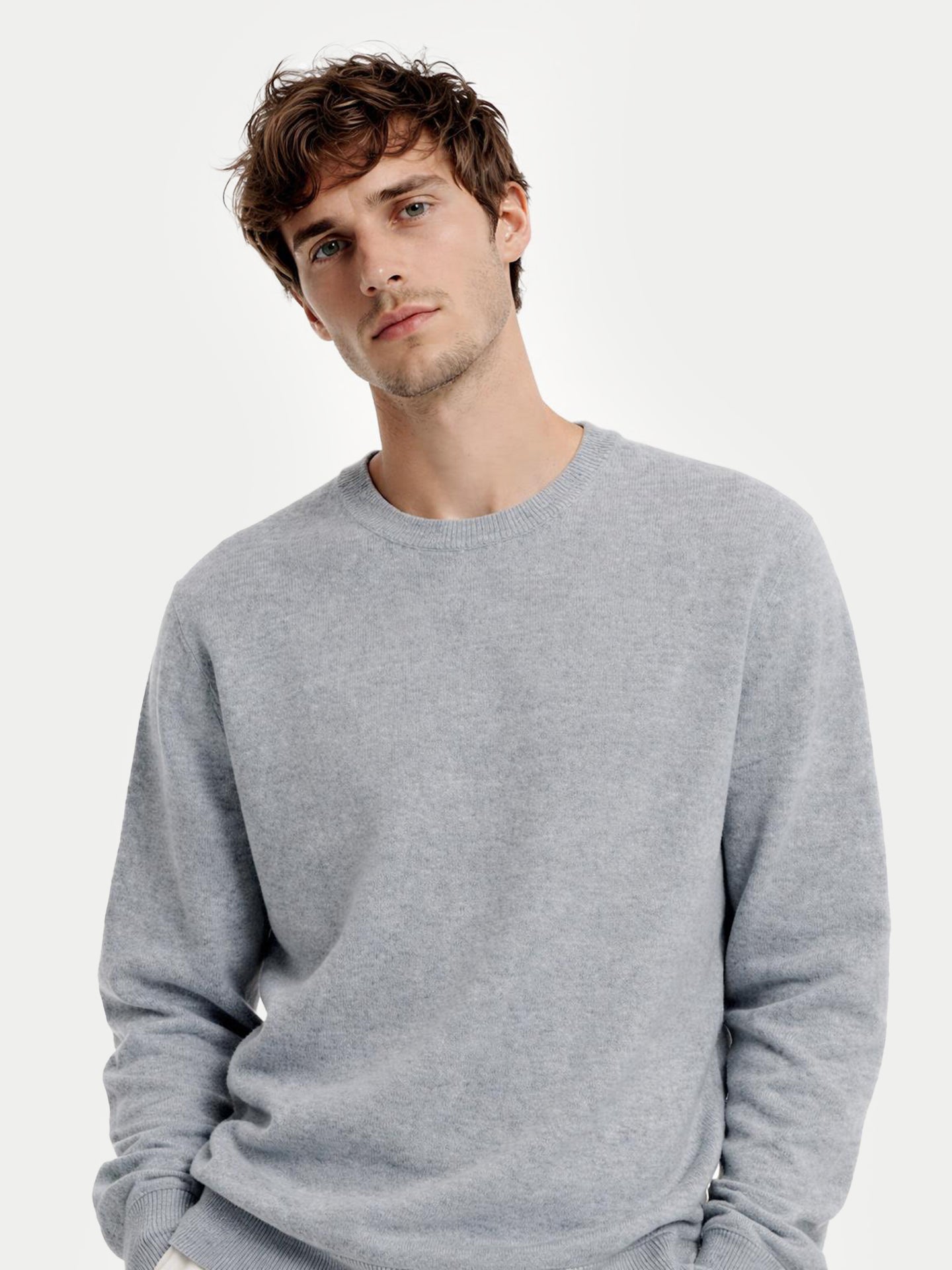 Man wearing a gray sweater against a white background