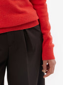 Red sweater and black pants on a white background. #color_red-orange