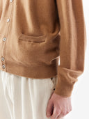 Brown cardigan with side pockets worn by a person on a white background. #color_light-brown