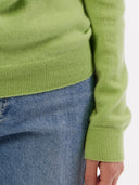 Green sweater worn by a person with a white background. #color_jade-green