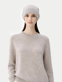 Woman wearing a gray knit beanie and sweater on a white background #color_dawn-blue