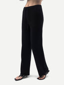 Black wide-leg pants with a drawstring waist, shown on a model from the waist down wearing black thong sandals against a light gray background.