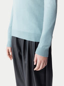 Light blue sweater worn by a person on a plain background. #color_cloud-blue #ai-image