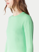 Person wearing a light green sweater on a white background. #color_soft-green