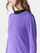 Purple sweater worn by a person on a light gray background. #color_purple #ai-image