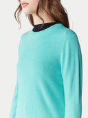 Teal sweater worn by a person on a white background. #color_aqua-green