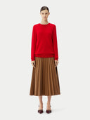 Person wearing a red sweater and brown pleated skirt on a white background. #color_true-red
