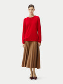 Person wearing a red sweater and brown skirt on a white background. #color_true-red