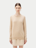 Woman wearing a beige sweater and skirt set on a white background. #color_beige