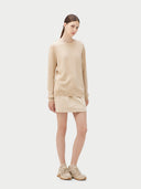 Woman wearing a beige sweater and skirt set on a white background. #color_beige